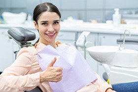 Female dental patient giving a thumbs up