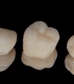 Three dental crowns in Marshall, TX sitting in a row 