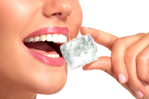 Woman biting down on an ice cube